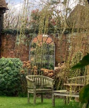 Architectural Arch Window Mirror looking at home on this aged walled area