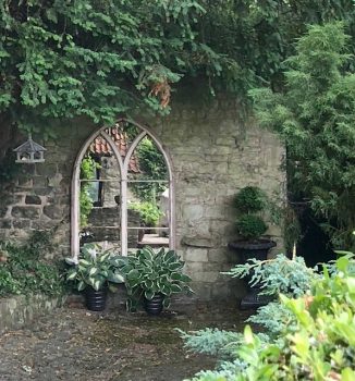 Large Chapel Arch Mirror positioned to bring light to this darker corner of our clients garden