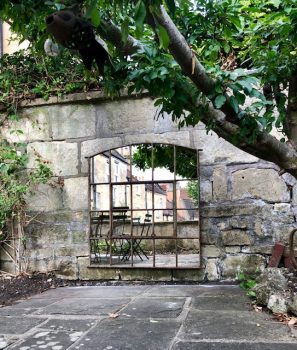 Slow Arch Vinatge Mirror positioned to reflect the rooftops of Bath, Somerset in our clients courtyard