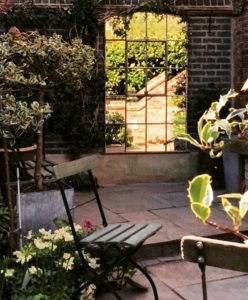 Tall Rustic Slow Arch Window Mirror bringing space and light to this darkened court yard area