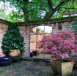 This Rustic Window Mirror brings depth and reflection detail to this walled area